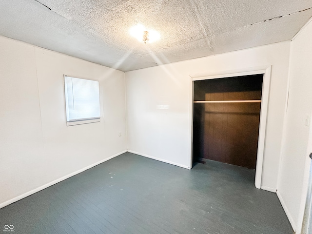 unfurnished bedroom with a textured ceiling and a closet