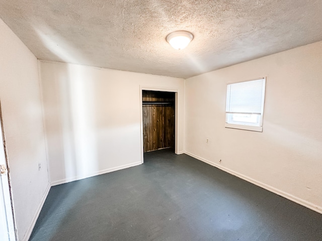 unfurnished bedroom with a textured ceiling and a closet