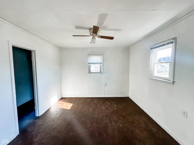 empty room with dark hardwood / wood-style flooring and ceiling fan