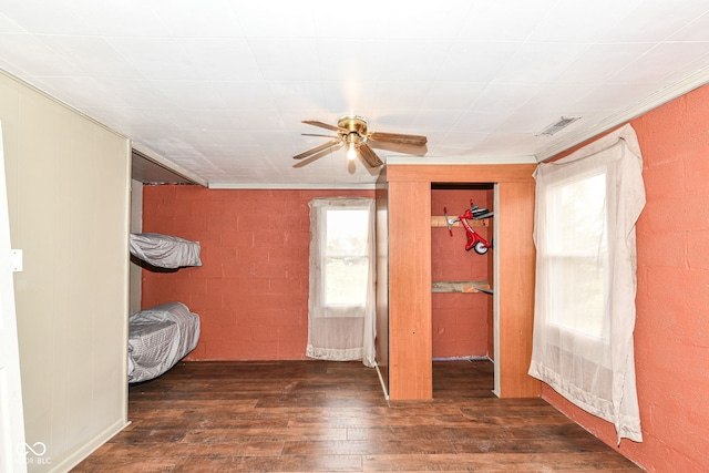 unfurnished bedroom with dark hardwood / wood-style floors, ceiling fan, and ornamental molding