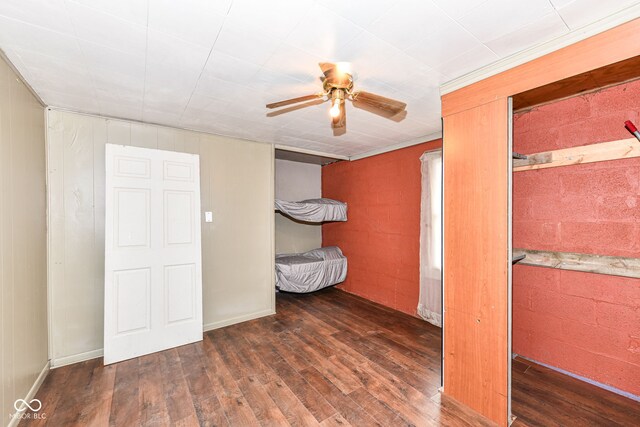 4925 W Raymond St, Indianapolis, IN 46241 - unfurnished bedroom with wood finished floors, ceiling fan, and concrete block wall