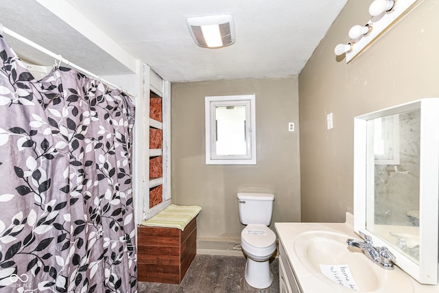 bathroom featuring curtained shower, a textured ceiling, toilet, vanity, and hardwood / wood-style flooring