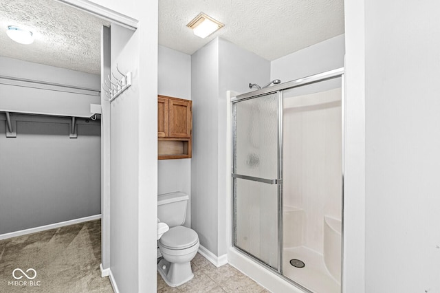 bathroom featuring toilet, an enclosed shower, and a textured ceiling