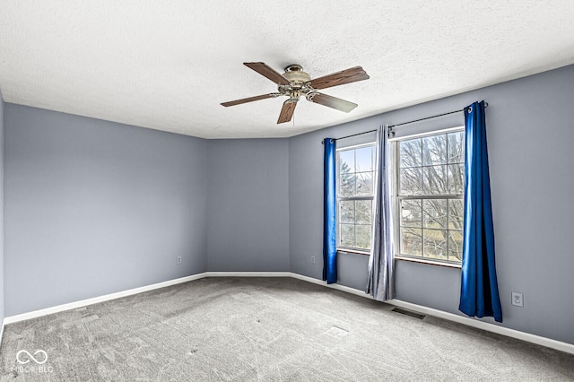 carpeted empty room with ceiling fan and a textured ceiling