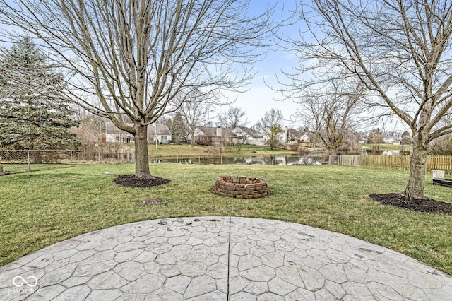 view of patio with a fire pit and a water view