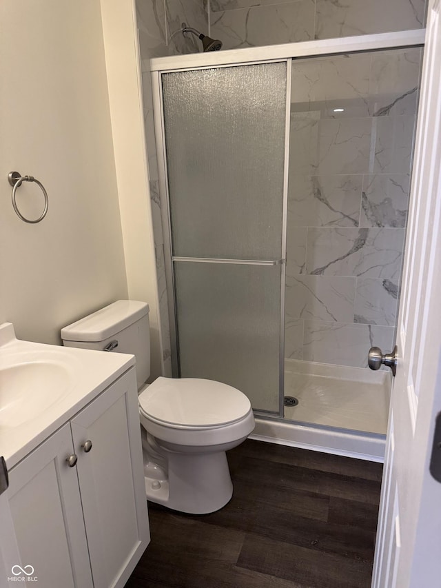 bathroom with hardwood / wood-style floors, vanity, toilet, and an enclosed shower