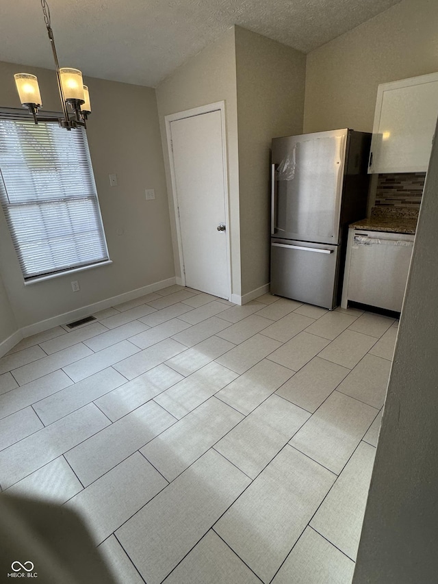 kitchen with dishwasher, white cabinets, hanging light fixtures, stainless steel fridge, and a textured ceiling