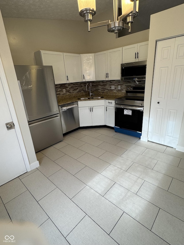 kitchen with decorative light fixtures, sink, white cabinetry, and stainless steel appliances