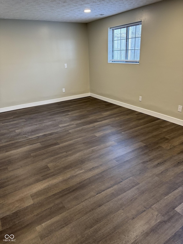 unfurnished room featuring a textured ceiling and dark wood-type flooring