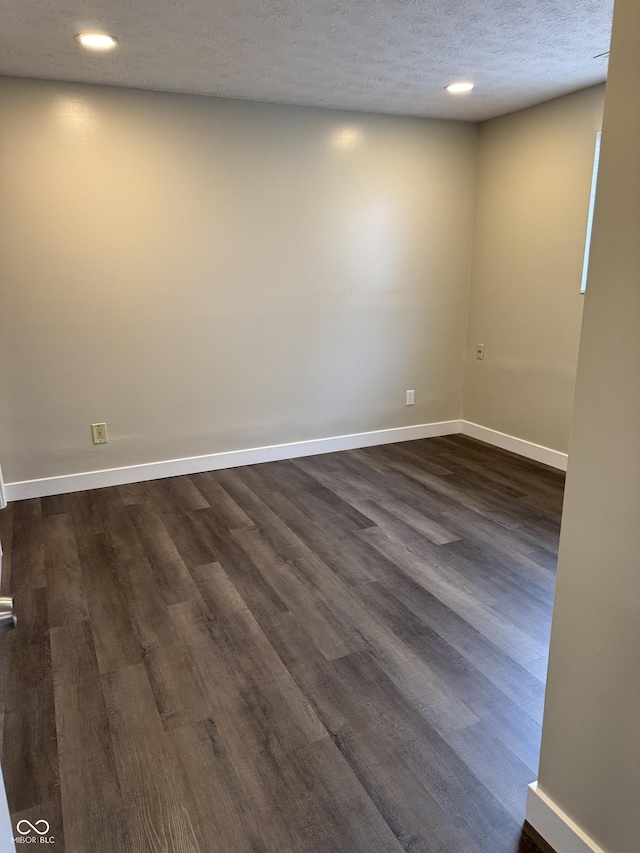 empty room featuring dark wood-type flooring and a textured ceiling