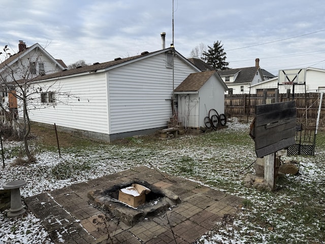 snow covered property featuring a patio area and an outdoor fire pit