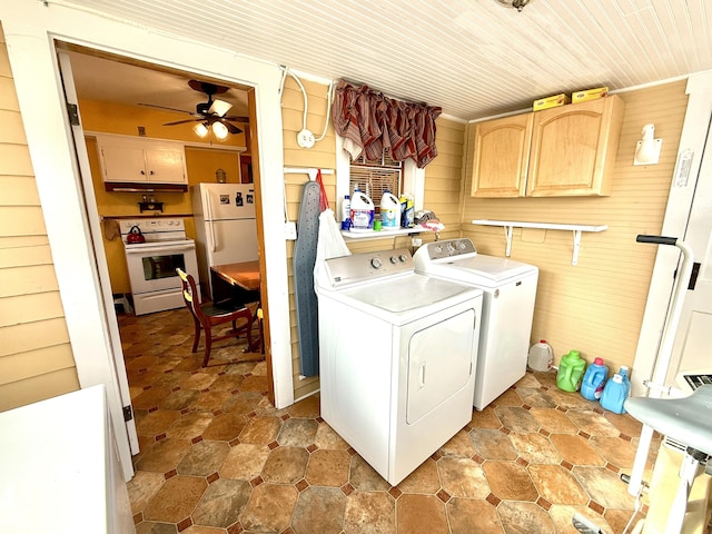 washroom featuring cabinets, ceiling fan, washing machine and dryer, and wooden walls