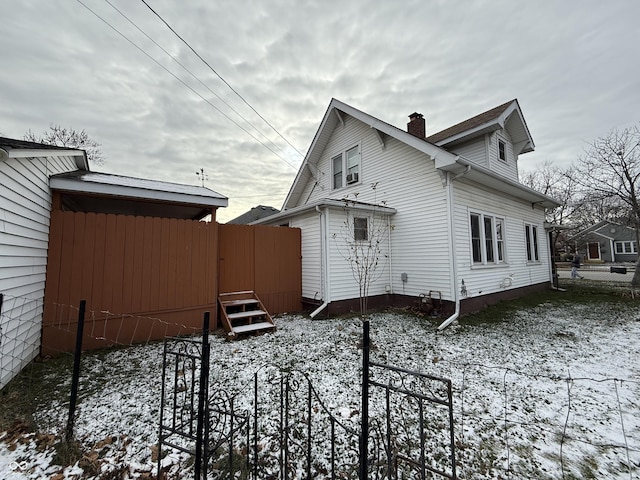 view of snow covered rear of property