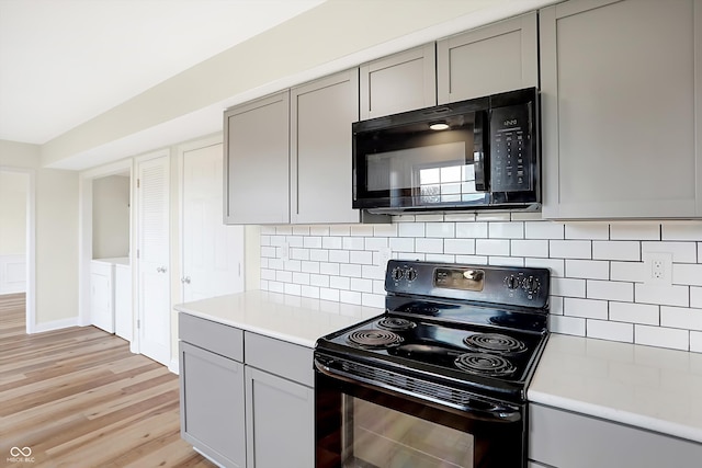 kitchen featuring black appliances, decorative backsplash, light hardwood / wood-style floors, and gray cabinets