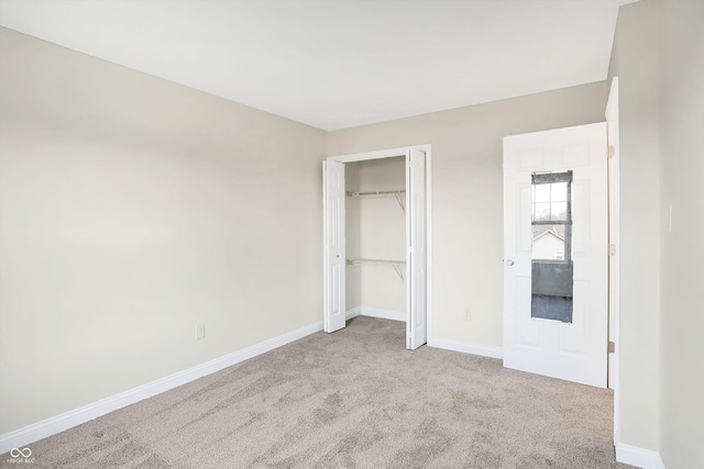 unfurnished bedroom featuring light carpet and a closet