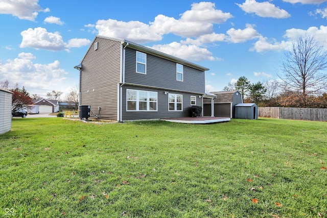 rear view of property featuring a shed, central AC unit, a wooden deck, and a lawn