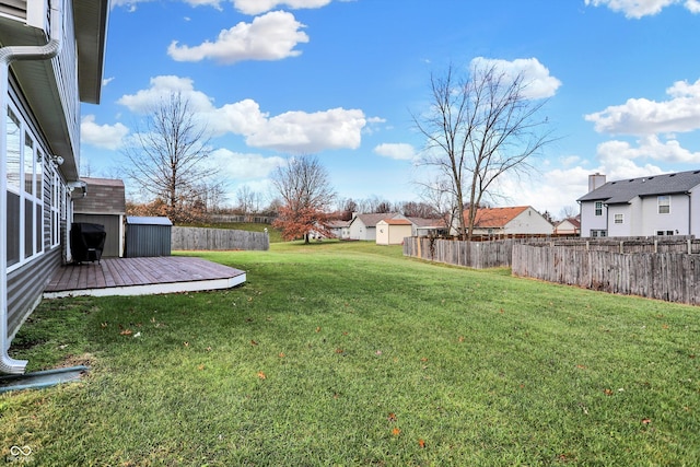 view of yard featuring a storage unit and a wooden deck