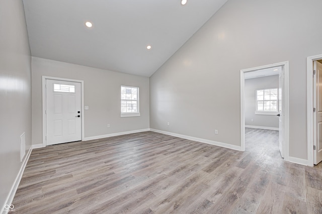 entrance foyer featuring light hardwood / wood-style flooring, high vaulted ceiling, and a wealth of natural light