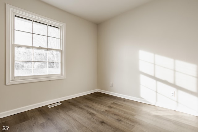 spare room with hardwood / wood-style flooring and a healthy amount of sunlight