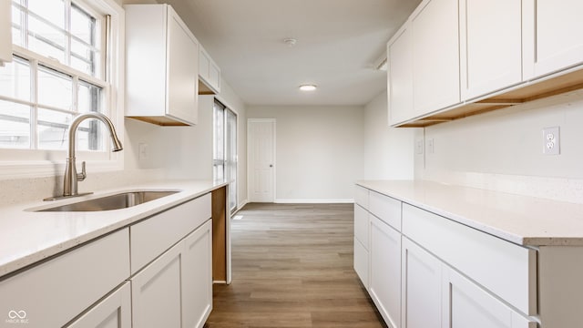 kitchen with sink, white cabinets, and light hardwood / wood-style floors