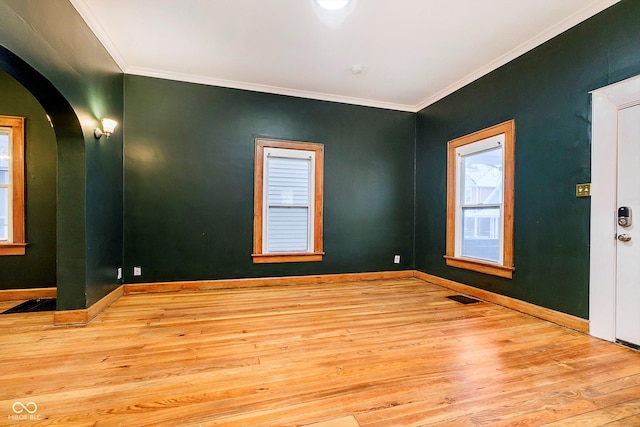 empty room with light hardwood / wood-style flooring and ornamental molding