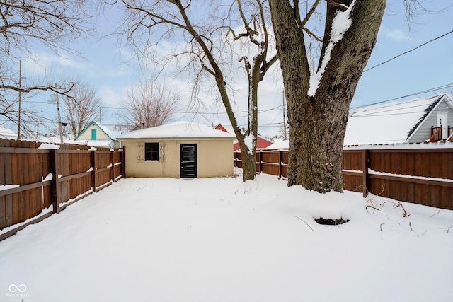 yard layered in snow with an outbuilding