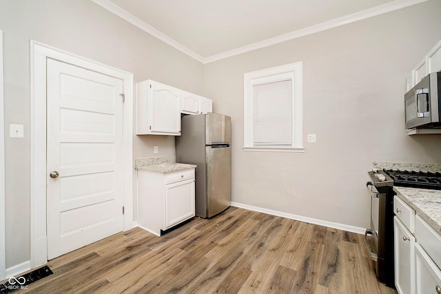 kitchen featuring light wood-type flooring, light stone counters, ornamental molding, stainless steel appliances, and white cabinetry