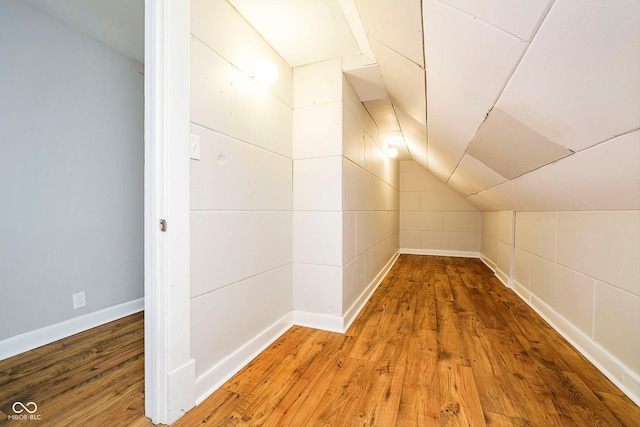 additional living space with hardwood / wood-style flooring and lofted ceiling