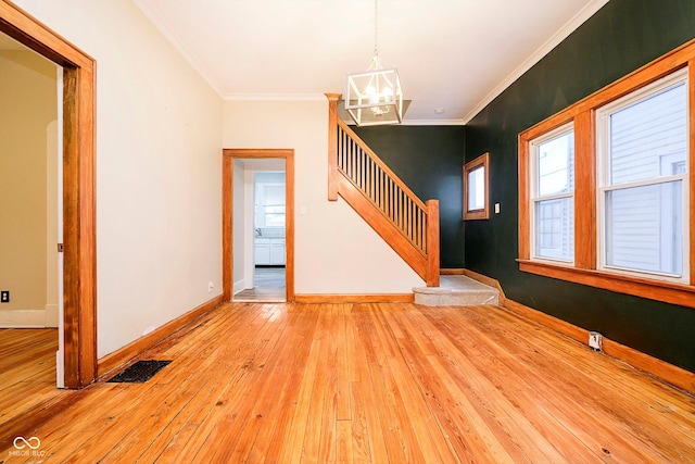 unfurnished living room featuring crown molding, light hardwood / wood-style floors, and a notable chandelier