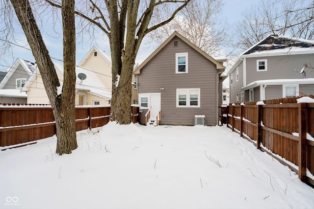 snow covered back of property with cooling unit