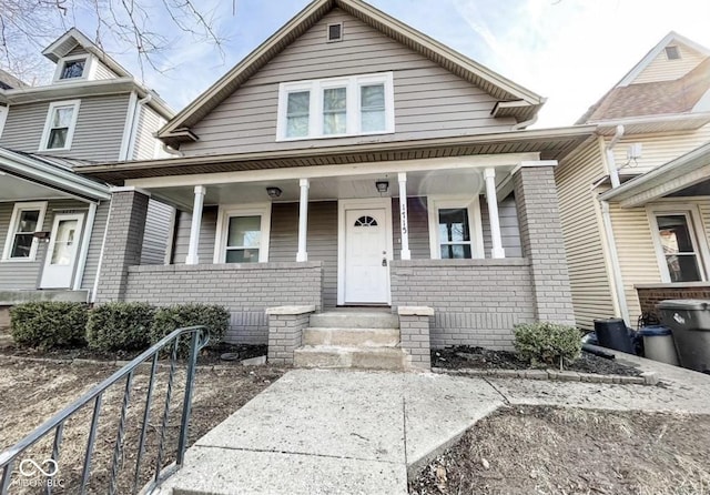 view of front of home with a porch and brick siding