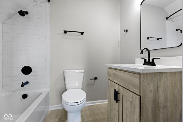 full bathroom with vanity, wood-type flooring, tiled shower / bath combo, and toilet