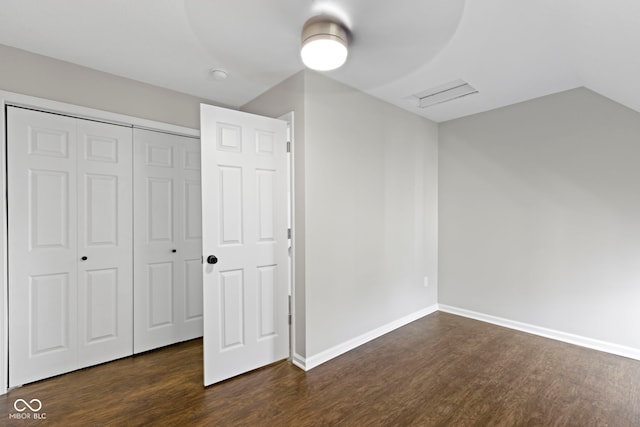 unfurnished bedroom featuring ceiling fan, lofted ceiling, dark wood-type flooring, and a closet