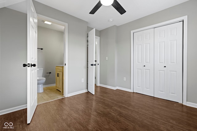 unfurnished bedroom featuring wood-type flooring, a closet, ceiling fan, and ensuite bathroom