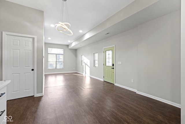 interior space with dark hardwood / wood-style floors and an inviting chandelier