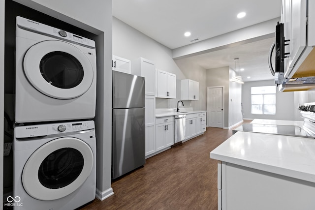 laundry room with sink, stacked washing maching and dryer, and dark wood-type flooring