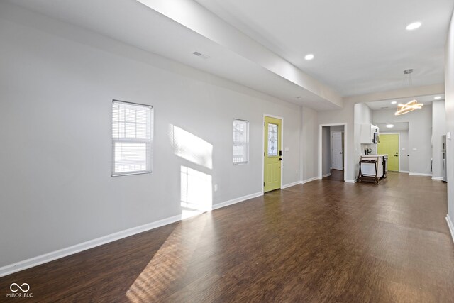 interior space featuring an inviting chandelier and dark wood-type flooring