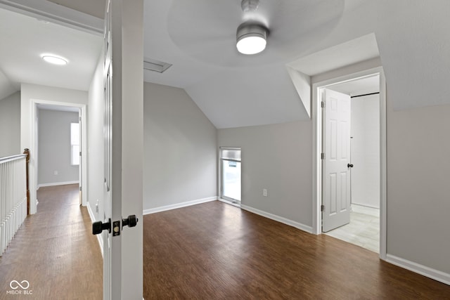 additional living space with hardwood / wood-style floors and lofted ceiling