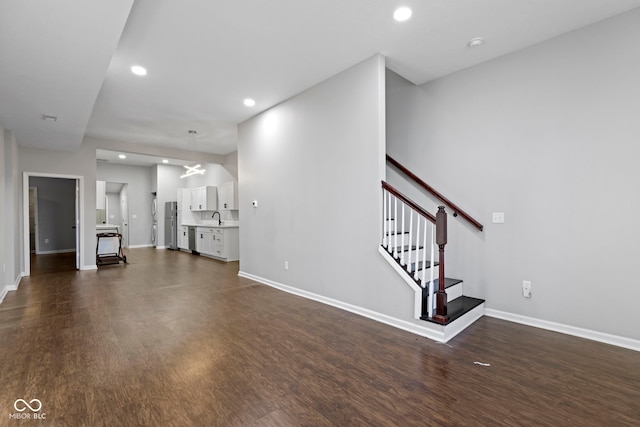 unfurnished living room with dark wood-type flooring and sink