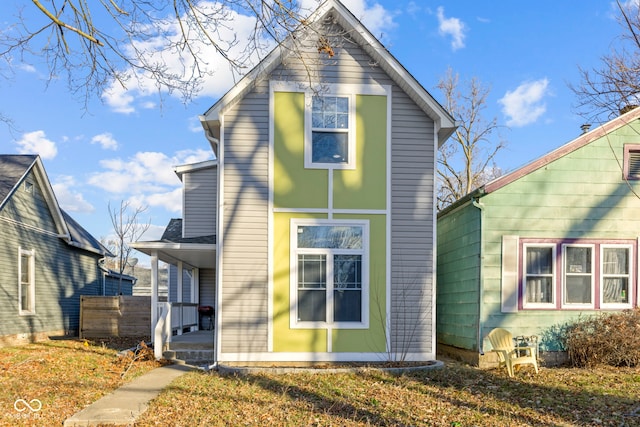 rear view of property with a lawn and covered porch