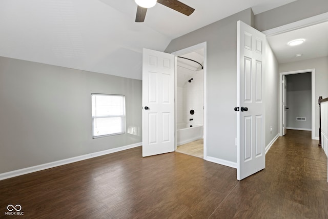 interior space with ceiling fan, dark hardwood / wood-style flooring, and vaulted ceiling