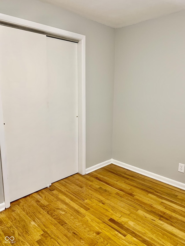 unfurnished bedroom with hardwood / wood-style flooring and a closet