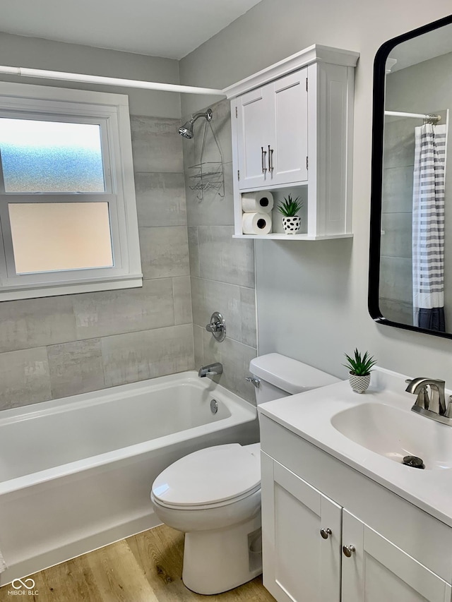 full bathroom with hardwood / wood-style flooring, vanity, toilet, and tiled shower / bath combo