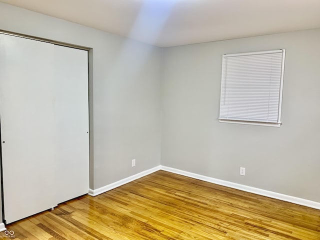 unfurnished bedroom featuring hardwood / wood-style floors and a closet