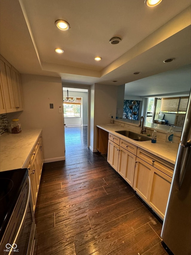 kitchen with black range with electric stovetop, sink, a tray ceiling, and dark wood-type flooring