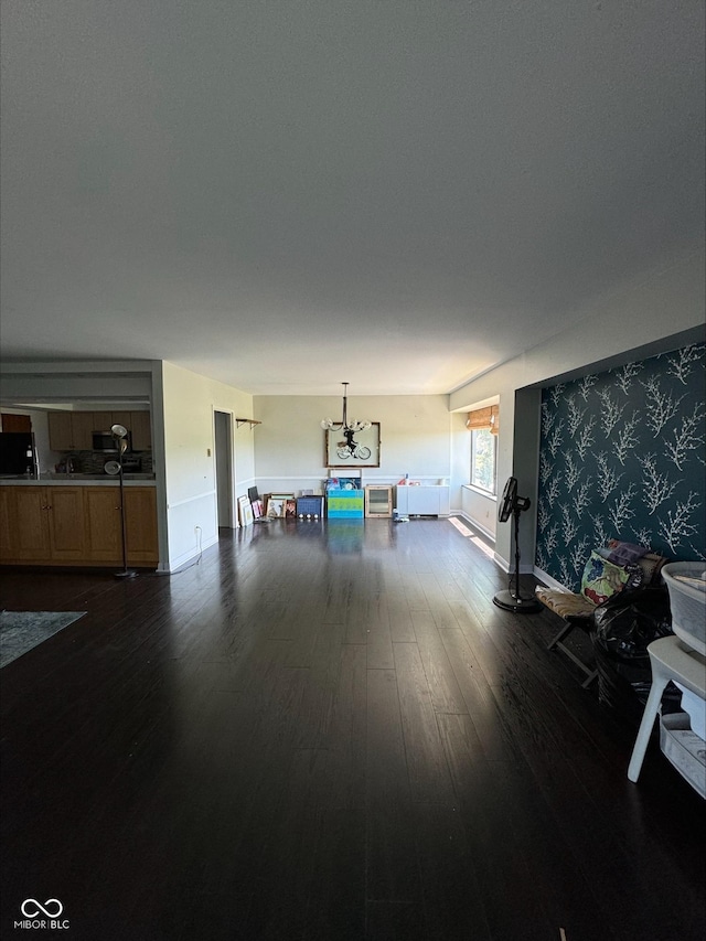 living room with dark hardwood / wood-style floors and an inviting chandelier