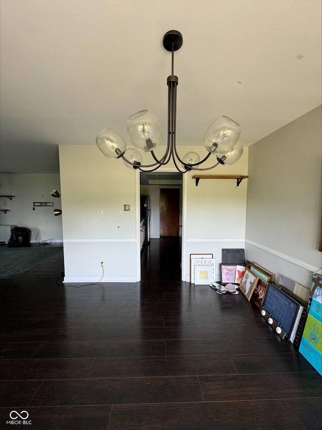 unfurnished dining area featuring dark hardwood / wood-style flooring and a chandelier