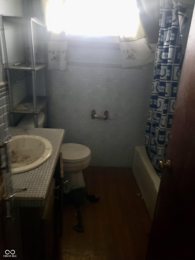 full bathroom featuring vanity, toilet, shower / bathtub combination with curtain, and wood-type flooring