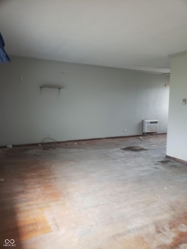 empty room featuring an AC wall unit and light hardwood / wood-style flooring