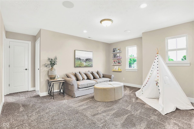 recreation room featuring dark carpet and a healthy amount of sunlight